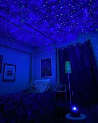 Blue starfield projected across a bedroom