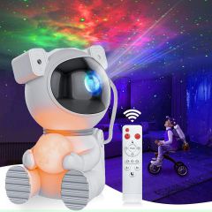 Moon astronaut star projector holding its lit moon lamp, coloured nebula on the wall behind it