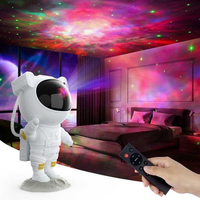 Astronaut sterrenprojector die een blauwe en paarse melkweg in een slaapkamer projecteert